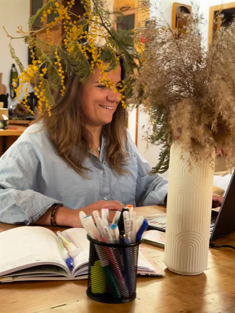 Lise souriante, en train de travailler à son bureau